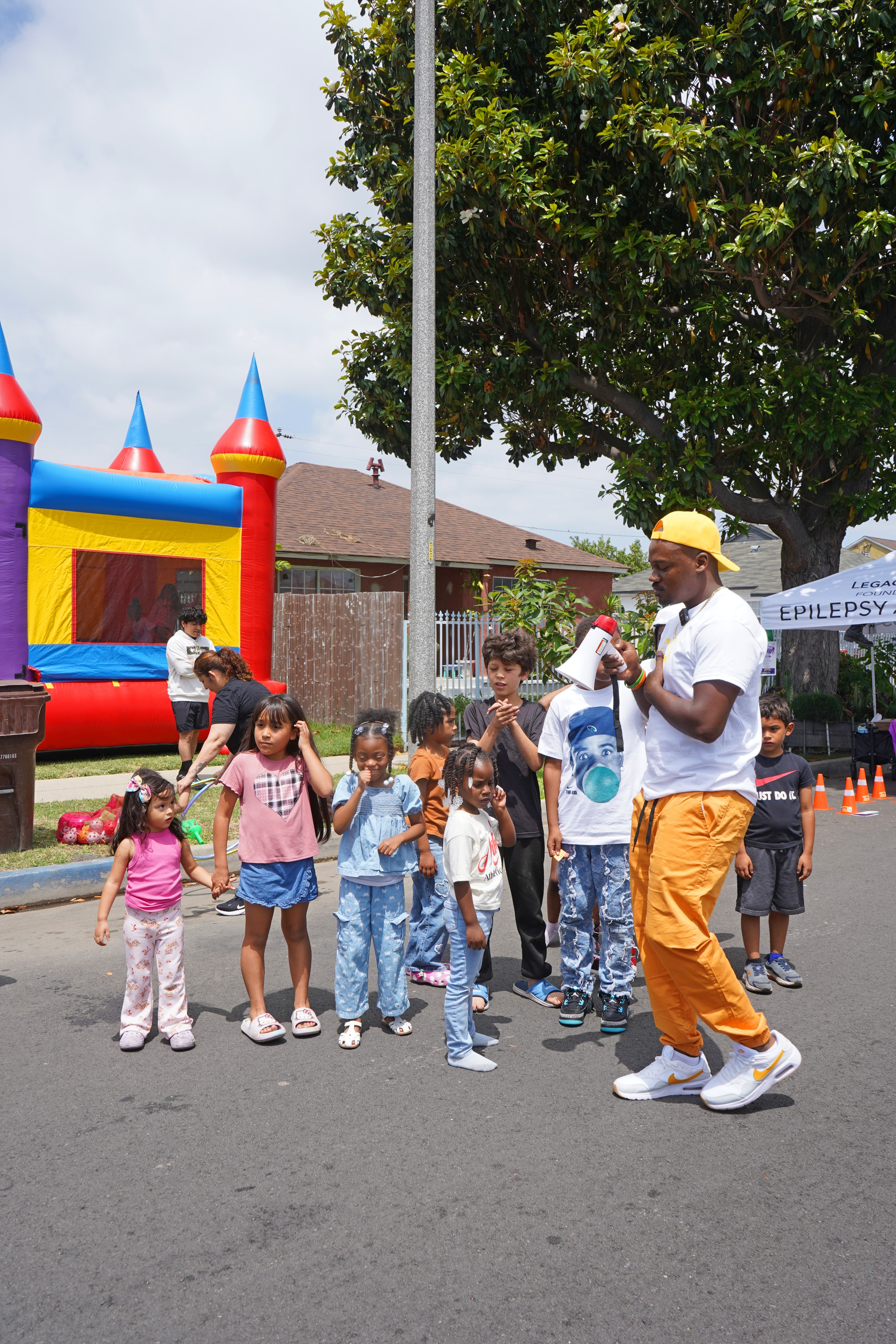 Kids lining up near the bounce house at the Compton field day