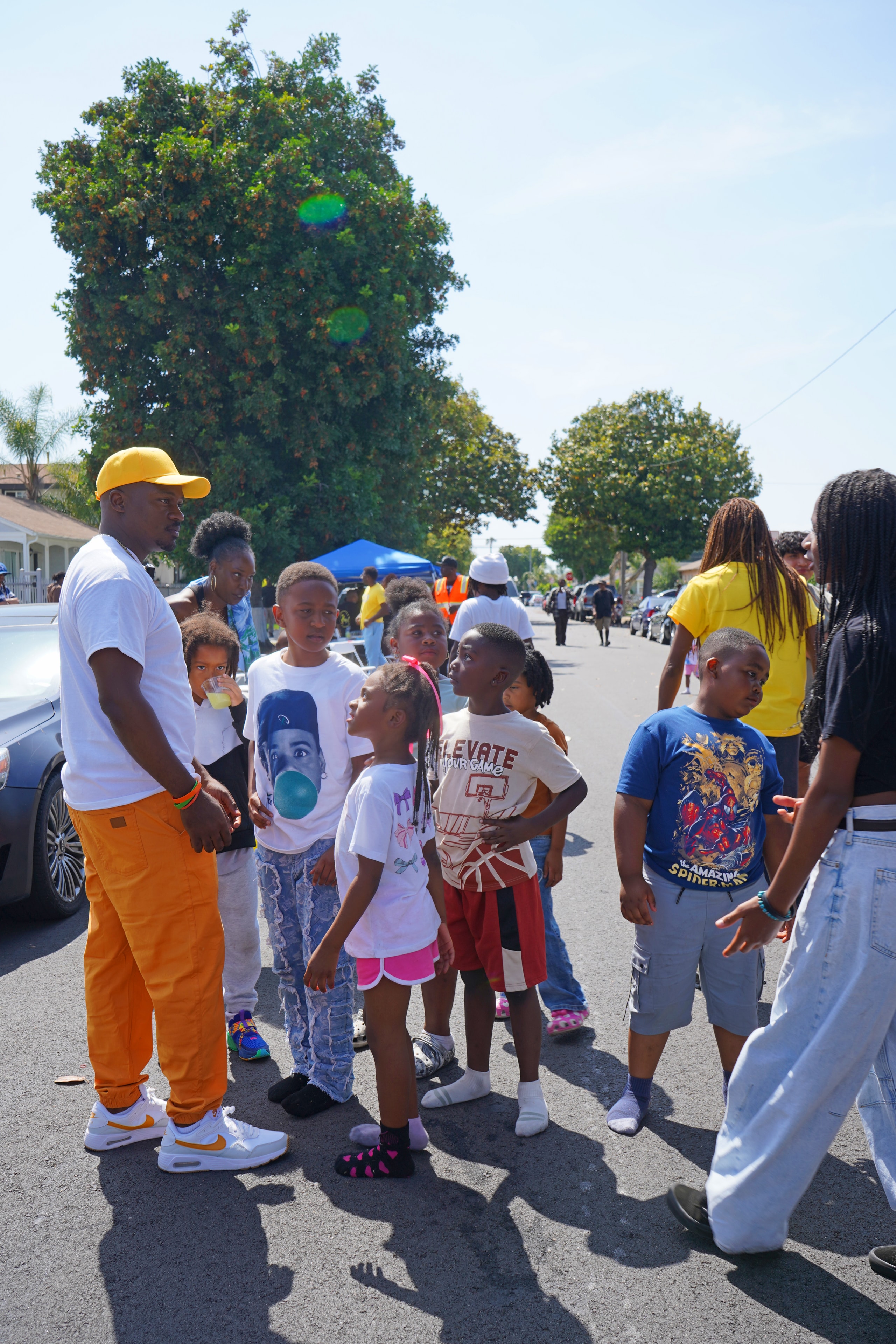 Community leader engaging closely with youth at the Compton field day