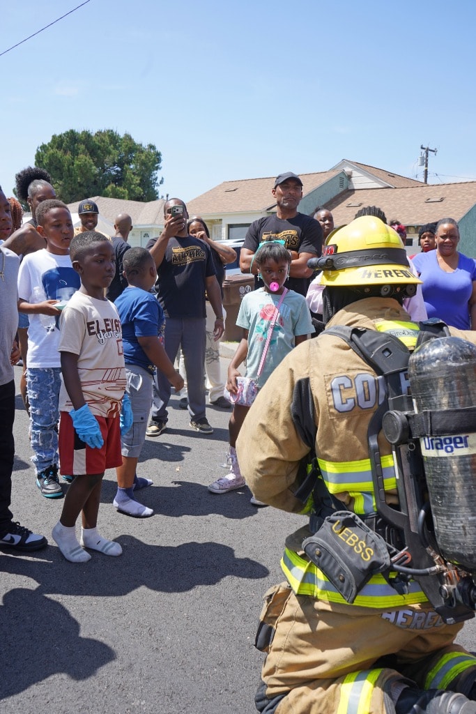 Children meeting a firefighter in full gear at the May 2026 Compton event